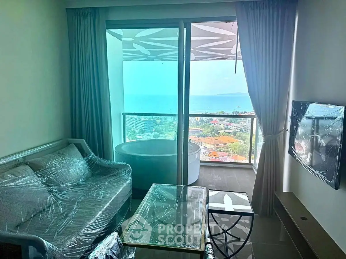 Modern living room with ocean view and large balcony in luxury apartment.