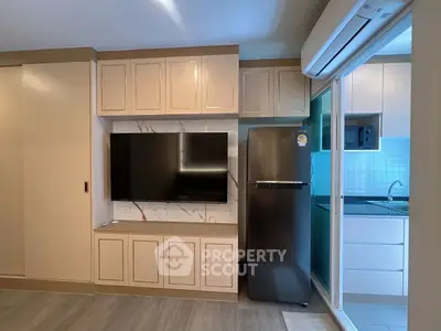 Modern kitchen with sleek cabinetry and stainless steel fridge in a stylish apartment.