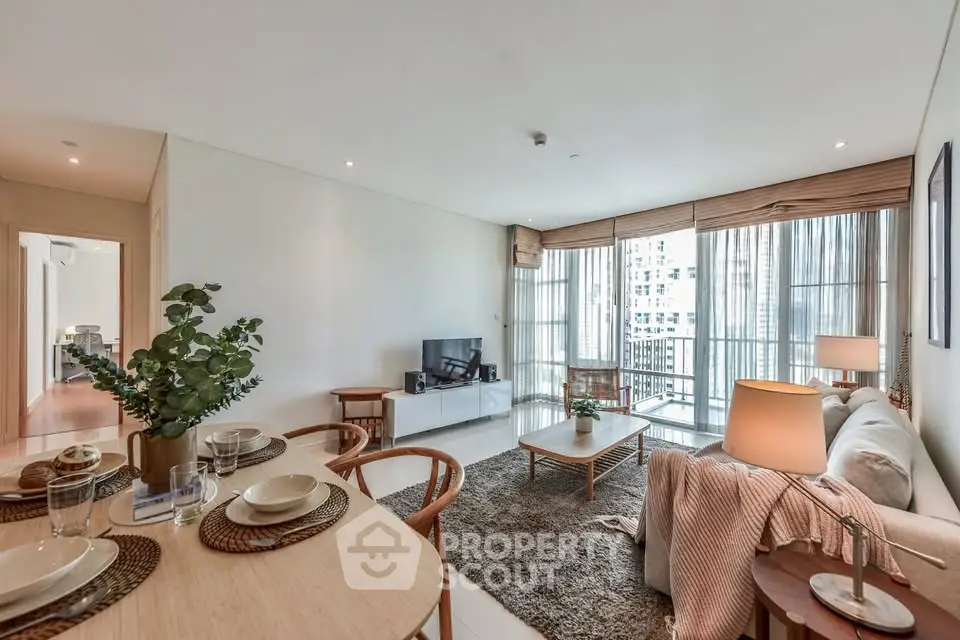 Spacious modern living room with elegant decor and large windows offering city views.