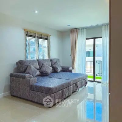Spacious living room with modern sectional sofa and large windows for natural light.