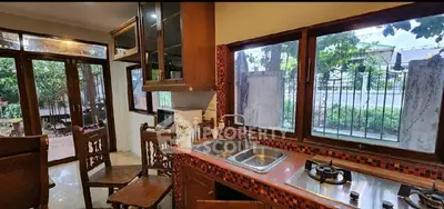 Charming kitchen with open layout and garden view, featuring wooden cabinetry and modern appliances.