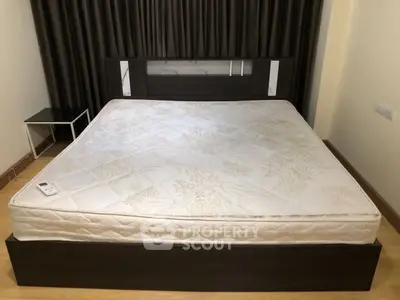 Spacious bedroom with modern bed and side table, ideal for comfort and relaxation.