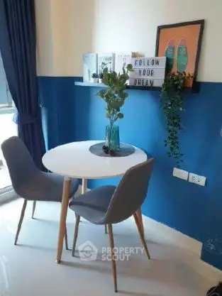Chic dining nook with modern decor and vibrant blue accent wall.