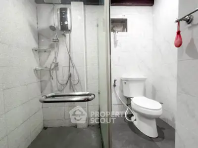 Modern bathroom with shower and toilet in sleek white design.