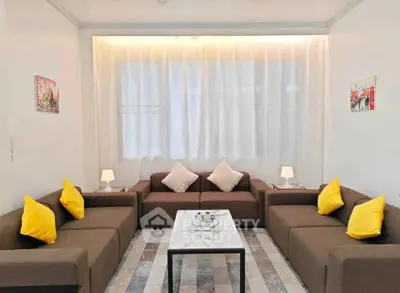 Stylish modern living room with brown sofas and yellow cushions, perfect for cozy gatherings.