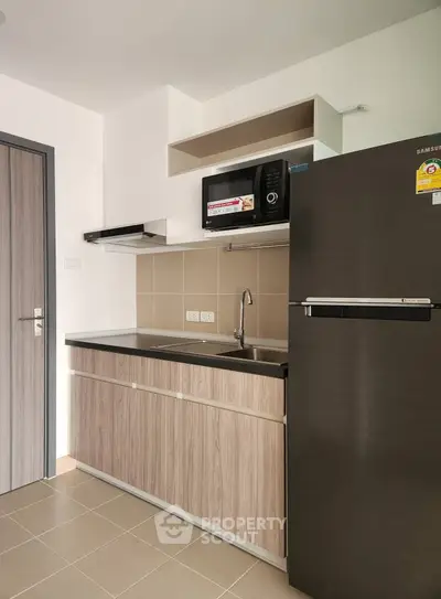 Modern compact kitchen with sleek appliances and stylish cabinetry