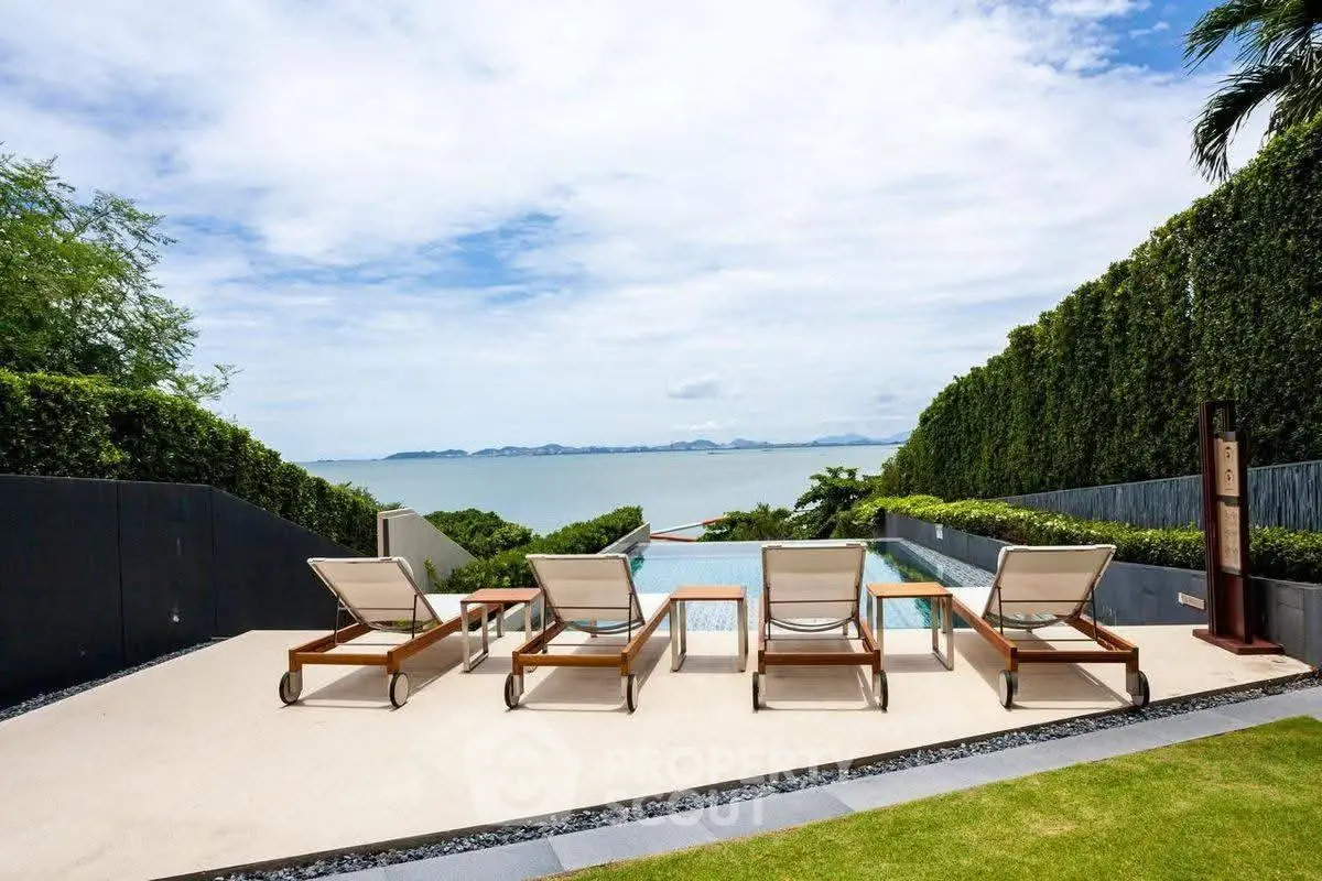 Luxurious poolside with stunning ocean view and elegant lounge chairs.