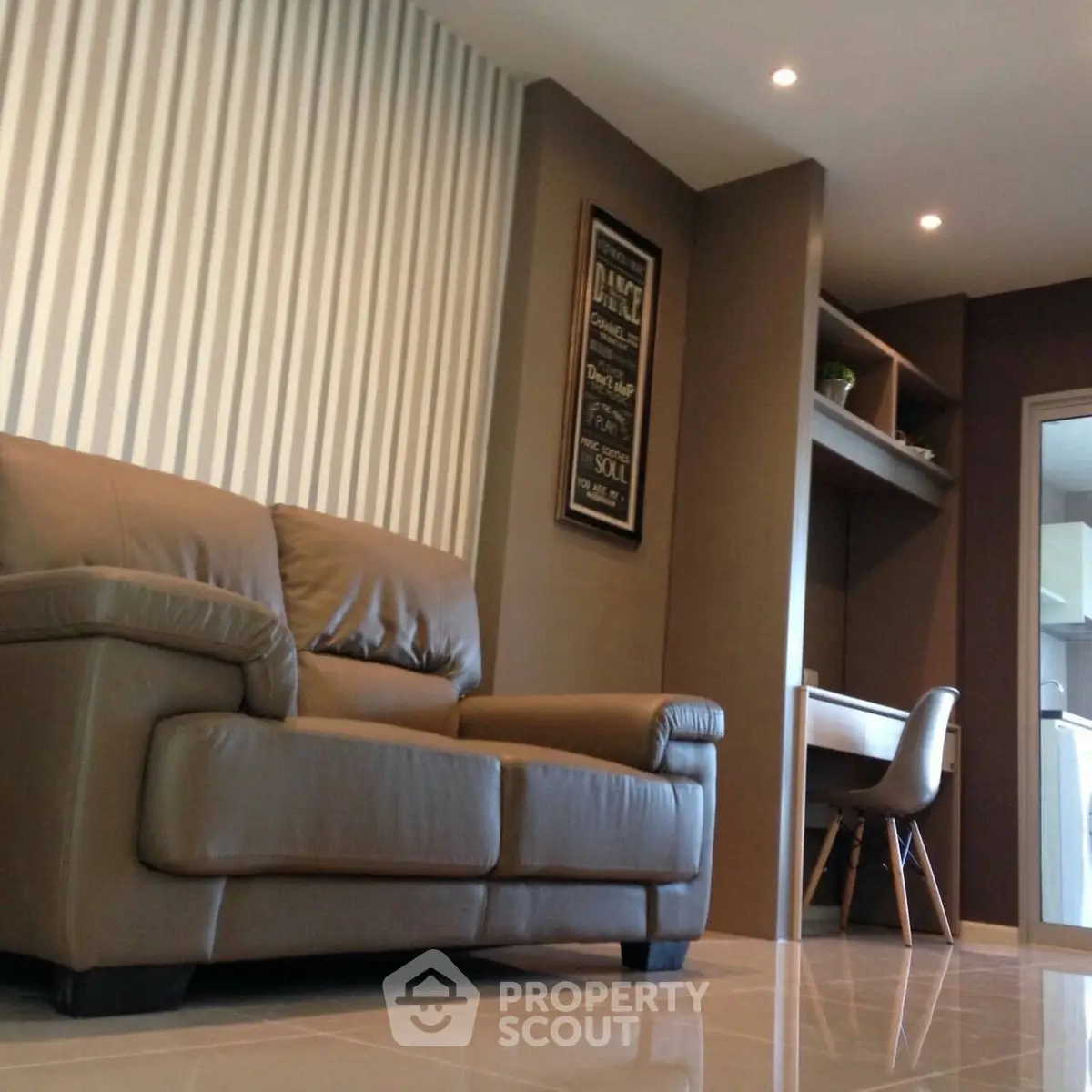 Modern living room with stylish leather sofa and built-in study area, perfect for urban living.