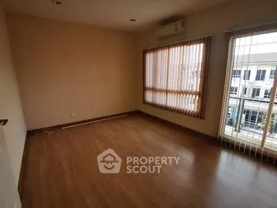 Spacious living room with large windows and ample natural light, featuring elegant wooden flooring and a serene view, perfect for modern living.