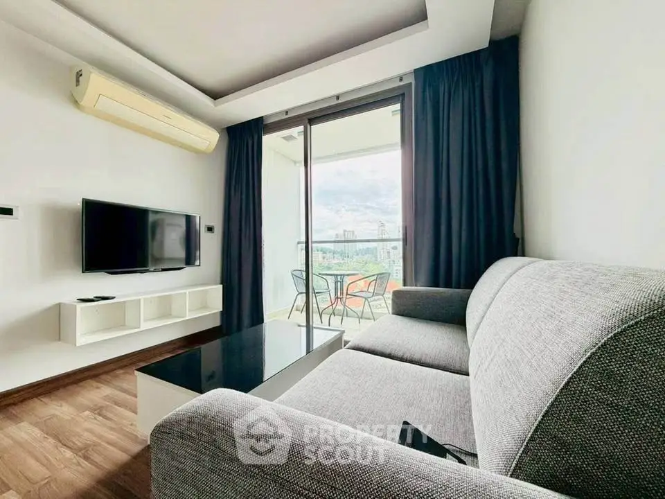 Modern living room with balcony view, featuring sleek furniture and natural light.