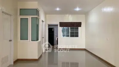 Spacious unfurnished living room with modern tile flooring and large windows for natural light.