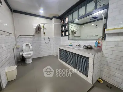 Spacious bathroom with modern fixtures and large mirror in a contemporary home.
