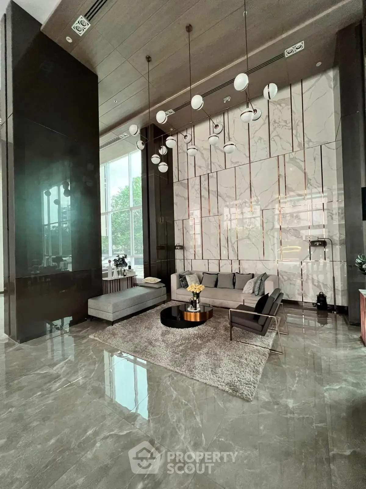 Luxurious modern living room with high ceilings, elegant lighting, and marble flooring.