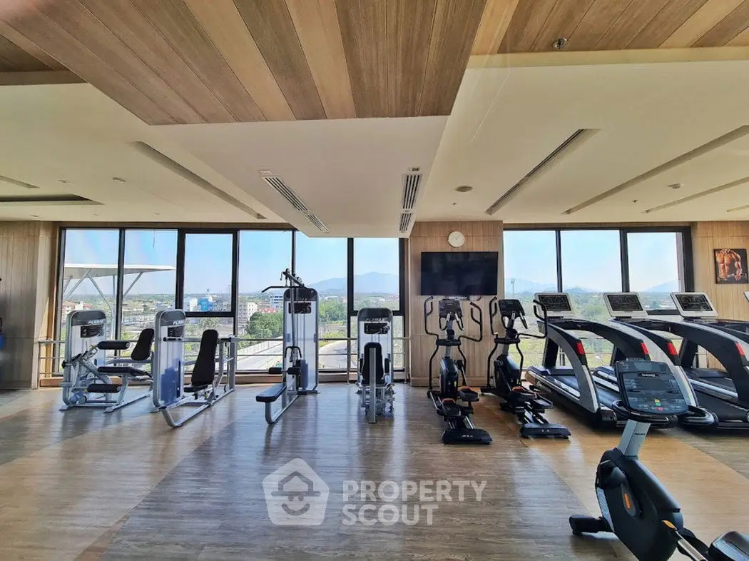 Spacious modern gym with panoramic windows and state-of-the-art fitness equipment.