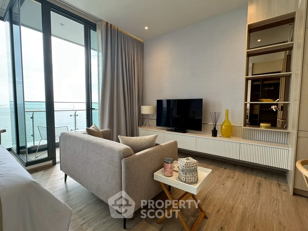 Luxurious living room with ocean view, modern decor, and floor-to-ceiling windows.