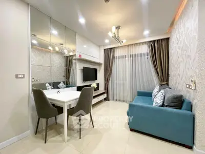 Elegant living room with modern decor, featuring a cozy blue sofa and stylish dining area.