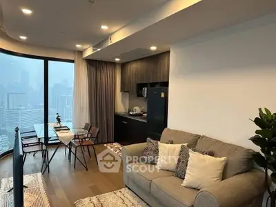 Modern living room with city view, featuring cozy sofa and dining area in open layout apartment.
