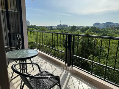 Spacious balcony with scenic green view and outdoor seating