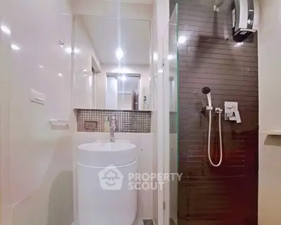 Modern bathroom with sleek shower and stylish sink in contemporary apartment.