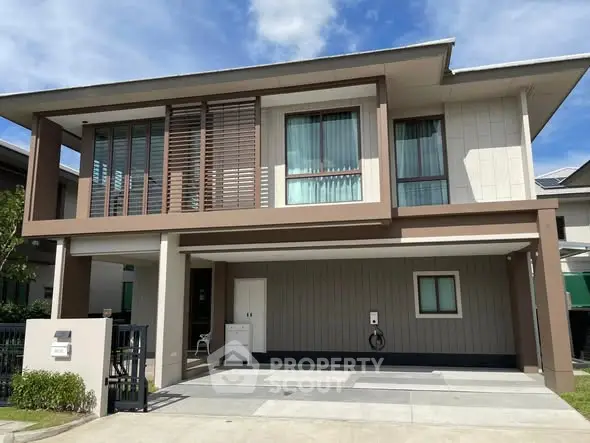 Modern two-story house with spacious driveway and contemporary design.