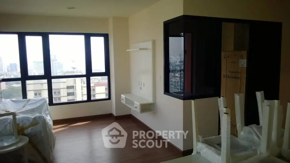 Bright and spacious living room with large windows and modern design in urban apartment.