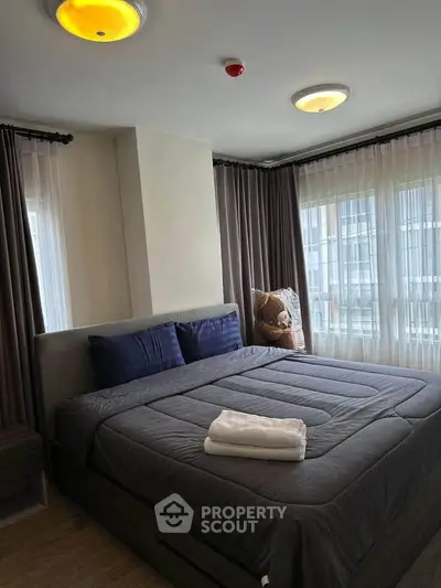 Spacious bedroom with large windows and modern decor in a stylish apartment.