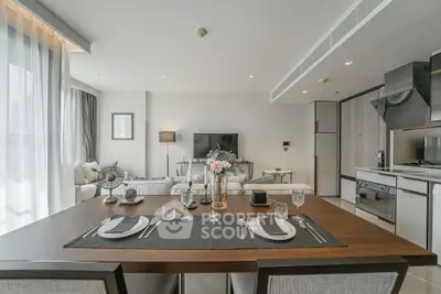 Modern open-plan living room and kitchen with elegant dining setup and stylish decor.