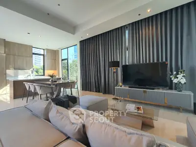 Luxurious open-plan living room with modern decor and large windows offering natural light.