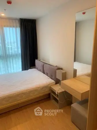 Modern bedroom with large window and stylish furniture in a contemporary apartment.
