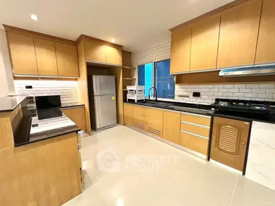 Spacious modern kitchen with wooden cabinets and sleek appliances