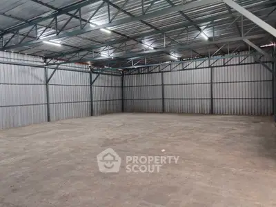 Spacious industrial warehouse with high ceilings and metal structure, ideal for storage or manufacturing.