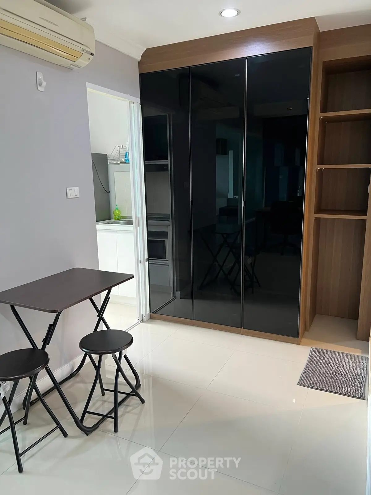 Modern compact living space with sleek black wardrobe and dining set