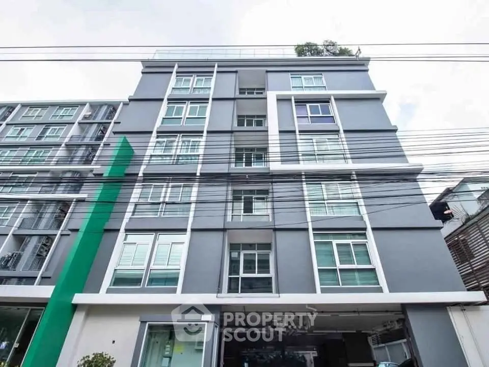 Modern multi-story residential building with sleek design and large windows.