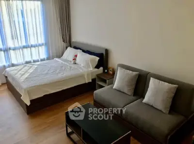 Modern bedroom with cozy bed and stylish sofa in bright apartment