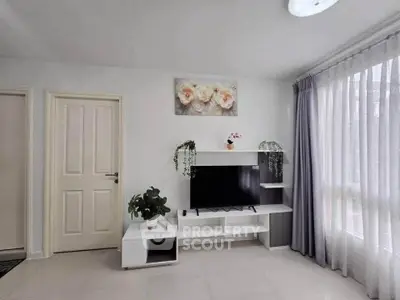 Modern living room with TV stand, plants, and large window with curtains.