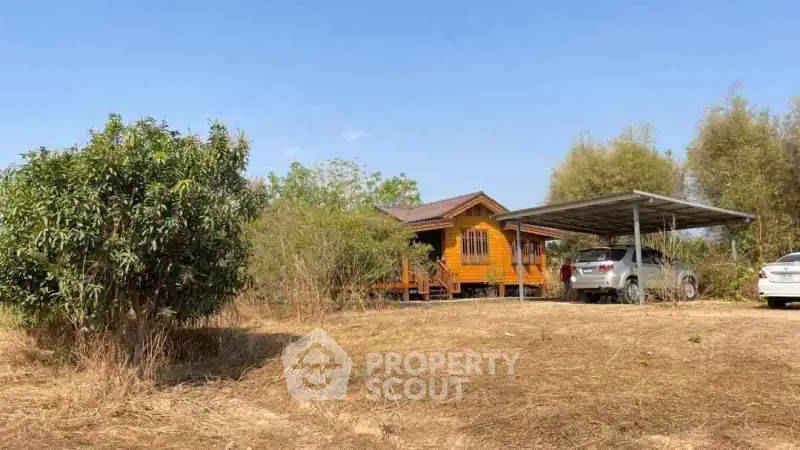 Charming rural property with wooden house and carport in a serene natural setting.