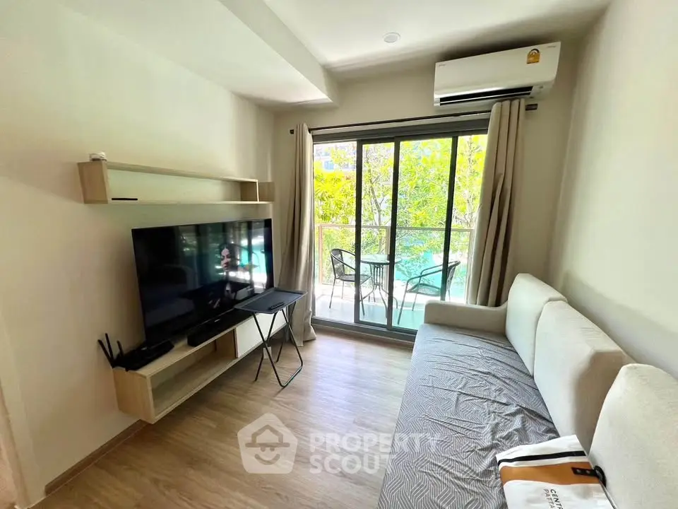 Modern living room with balcony view, featuring sleek furniture and natural light.
