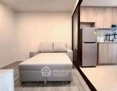 Modern living room with sofa bed and open kitchen layout in a stylish apartment.