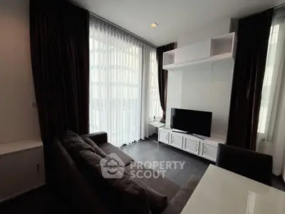 Modern living room with sleek furniture and large windows in a stylish apartment.