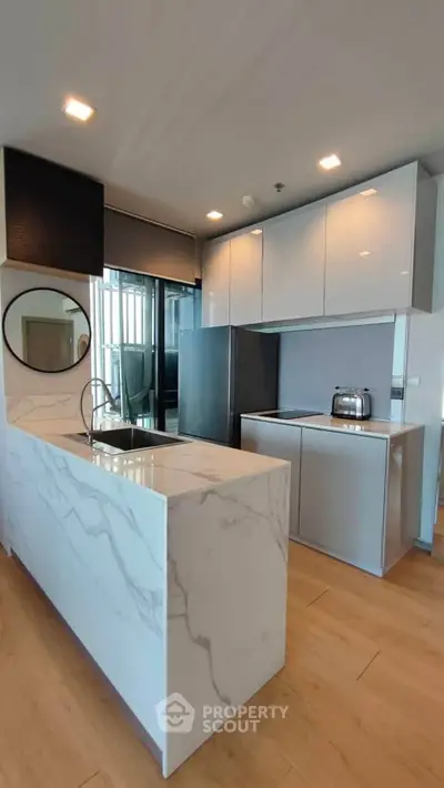 Modern kitchen with sleek cabinets and marble island in luxury apartment