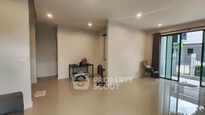 Spacious modern living room with large windows and glossy tiled floors