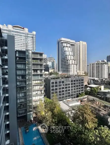 Stunning cityscape view from high-rise building with pool and lush greenery