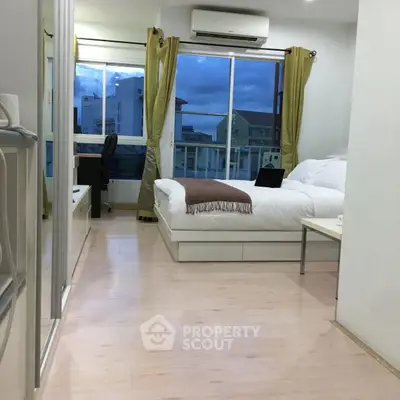 Modern bedroom with large window and city view, featuring sleek furniture and cozy ambiance.