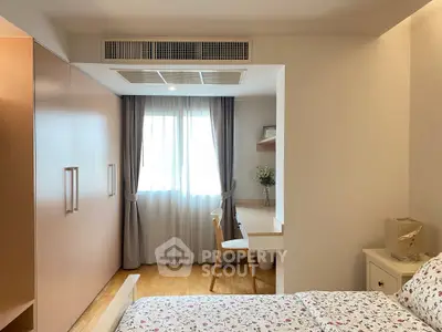 Cozy bedroom with built-in wardrobe and study nook, featuring natural light and elegant decor.
