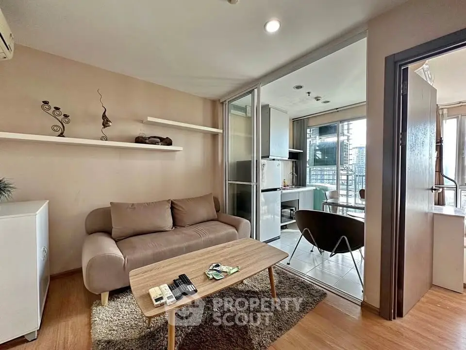 Modern living room with cozy sofa and open kitchen layout in a stylish apartment.