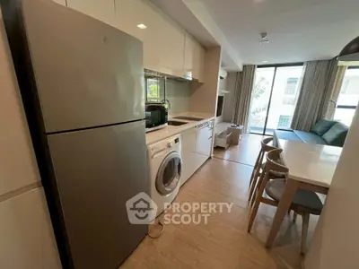 Modern open-layout kitchen and living area with natural light and sleek appliances.