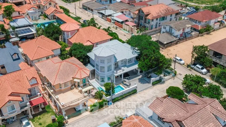Aerial view of suburban neighborhood with modern houses and lush greenery.