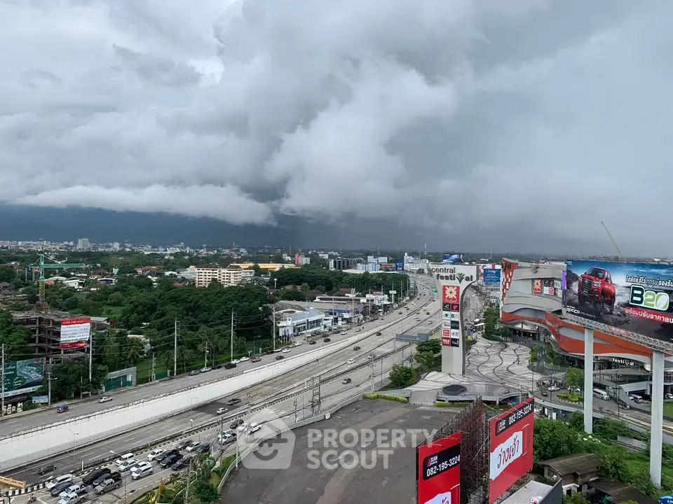 Stunning cityscape view with dramatic clouds over a bustling highway and shopping center.