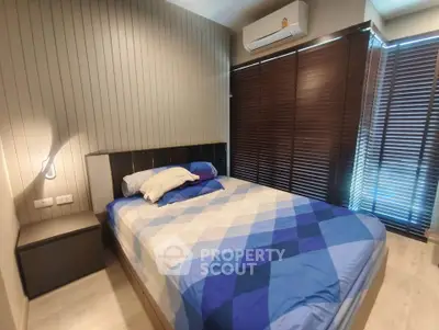 Cozy bedroom with modern decor and natural light from large windows.