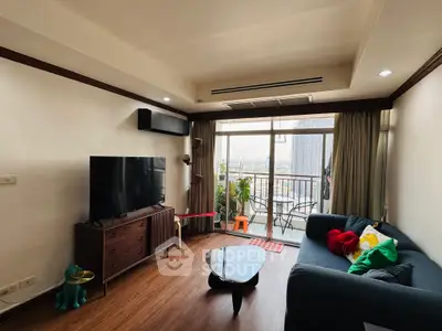 Spacious living room with modern decor and balcony view in urban apartment.